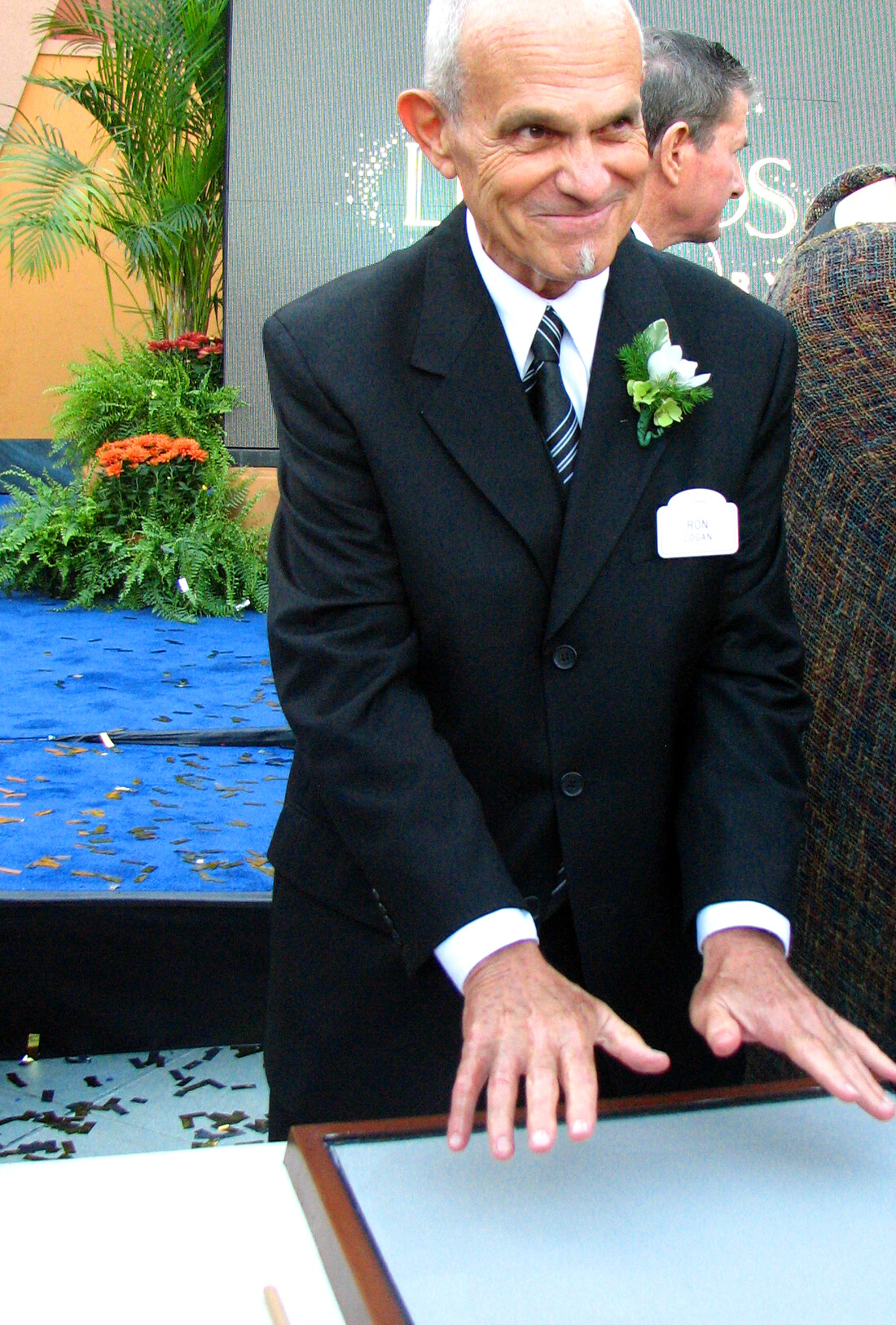 Ron Logan pressing his handprints into the cement at the Disney Legends ceremony